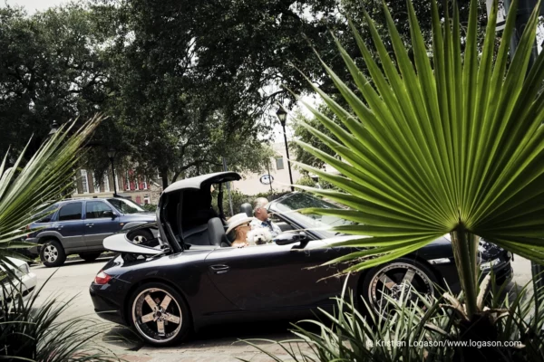 people with a dog in a convertible car