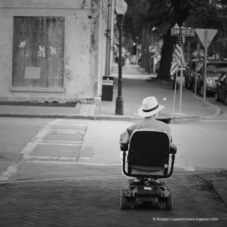 Man riding around in a wheelchair with the american flag on it