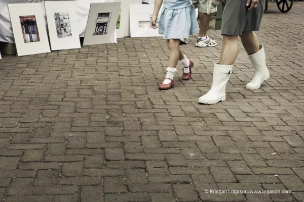 art at display as two women in rubber boots walk by at the farmers market in , Charleston, South Carolina