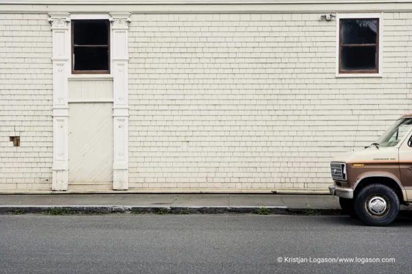 Brown van in front of a wood tile wall building in Ferndale, California