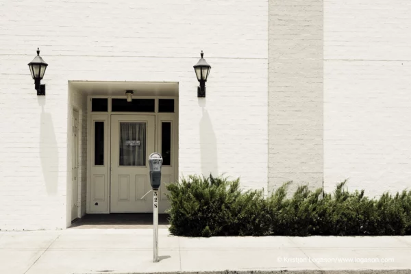 Parking meter on a sidewalk in front of a white wall building in Savannah, Georgia 2006